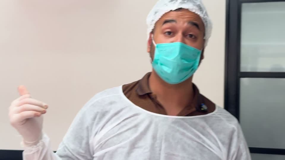Cirurgião de gorro, máscara e avental explicando o procedimento